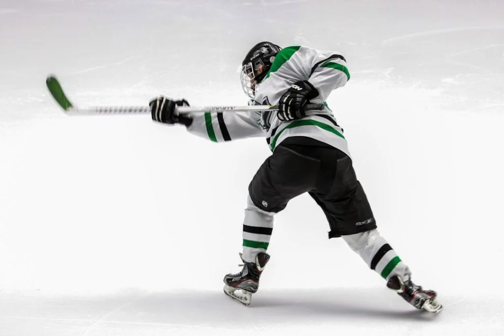 College ice hockey player shooting on the rink, evoking the world of Off Campus on Prime Video
